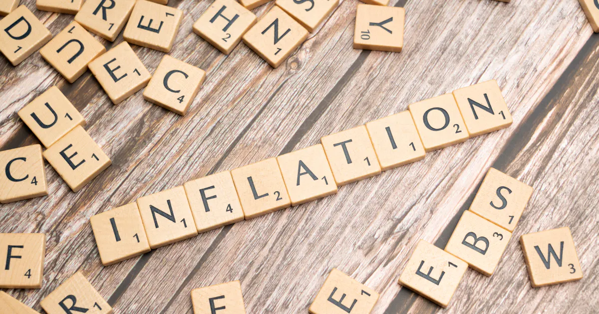 Wooden letter tiles spelling INFLATION — how inflation affects savings in Pakistan